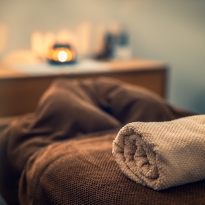 spa table with towel and lit candle glowing in the back